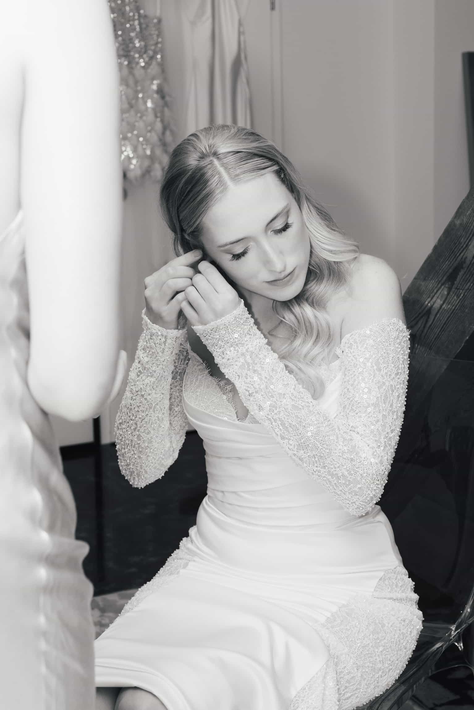 Bride in a beaded white gown with long sleeves, eyes closed in peaceful reflection, getting-ready portrait