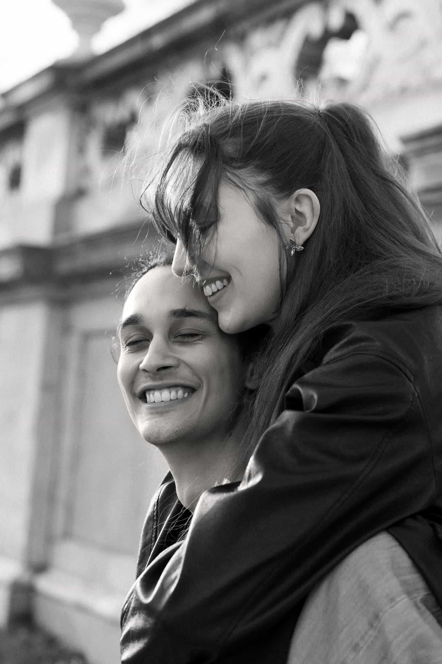Documentary candid of bride and groom laughing together against an urban building backdrop